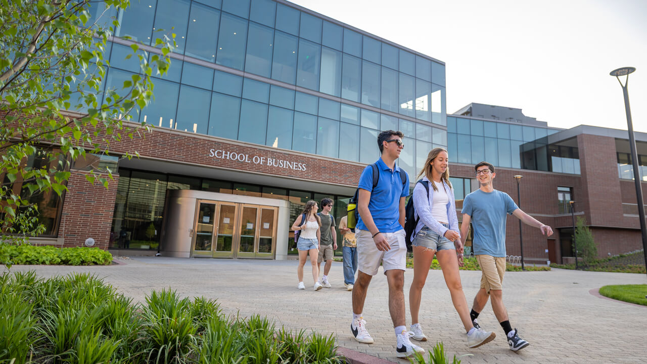 Students walk in front of the School of Business on the South Quad on a sunny day
