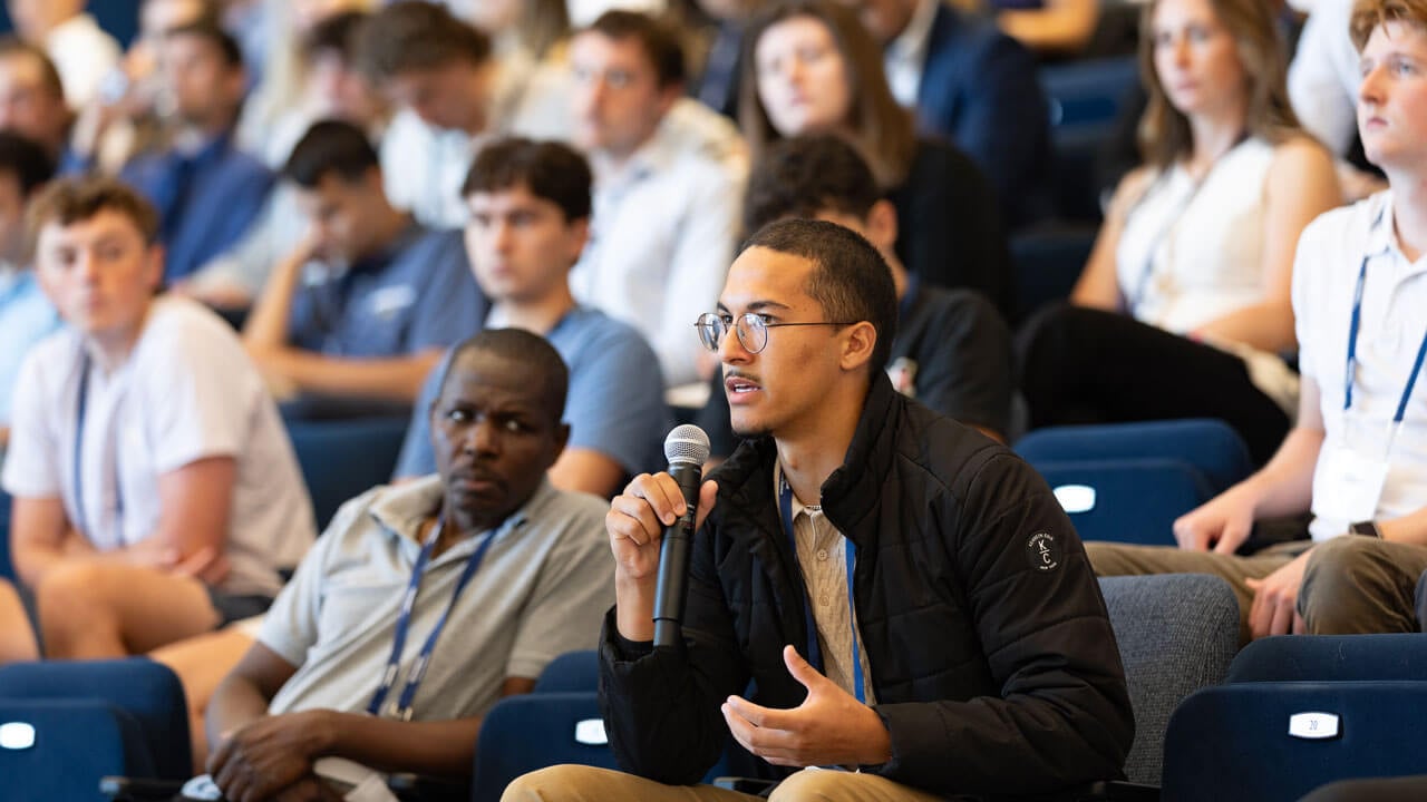 Audience member asks a question during symposium