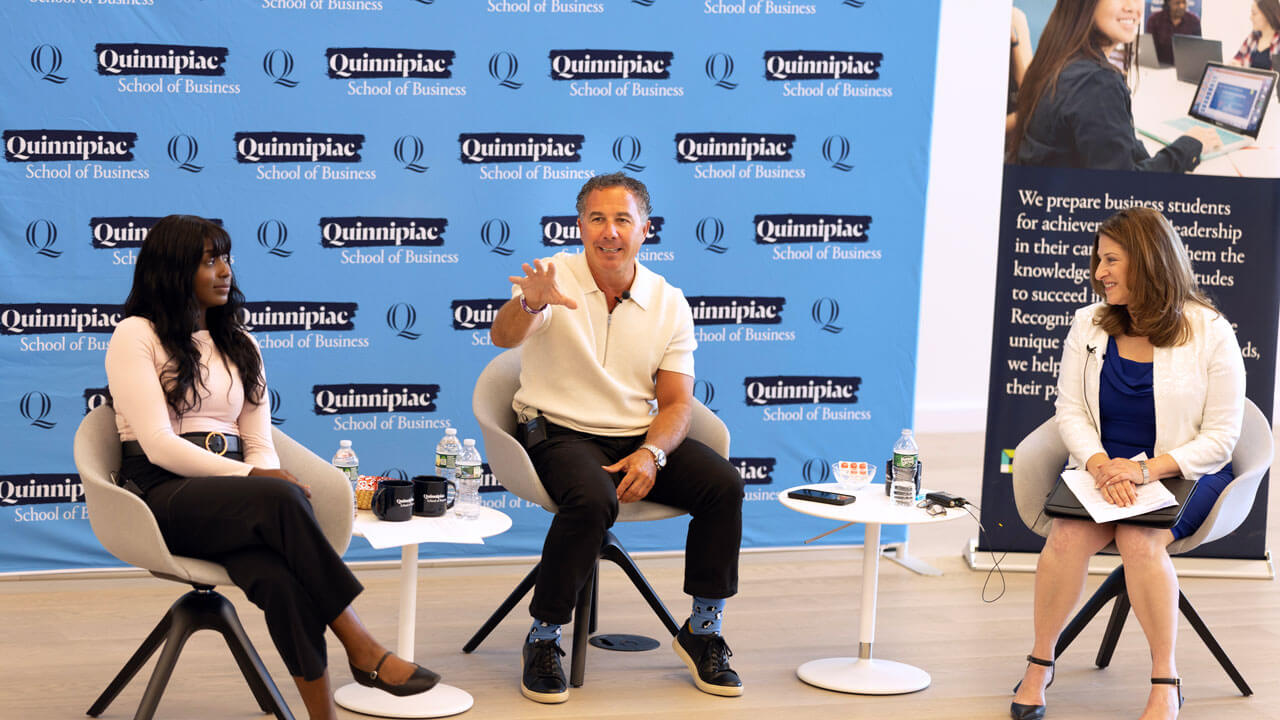 Chuck Saia talks to crowd alongside Holly Raider and business student