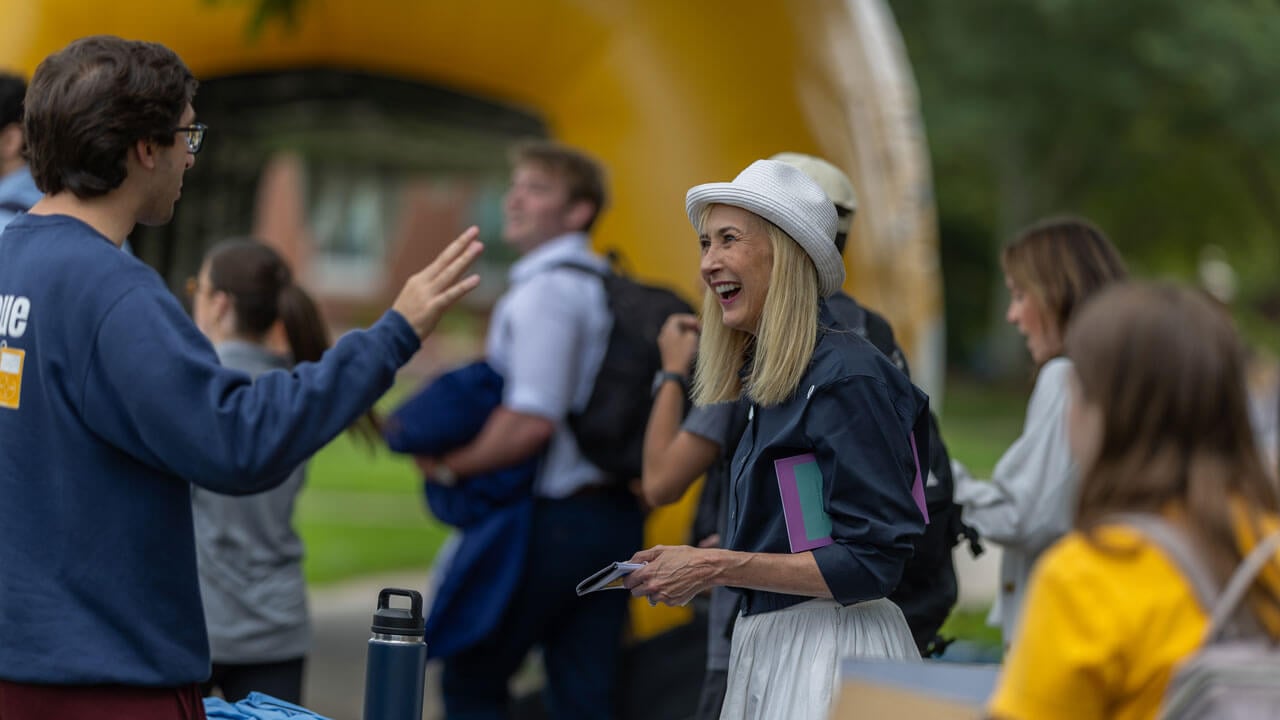 Quinnipiac President enthusiastically talks to student