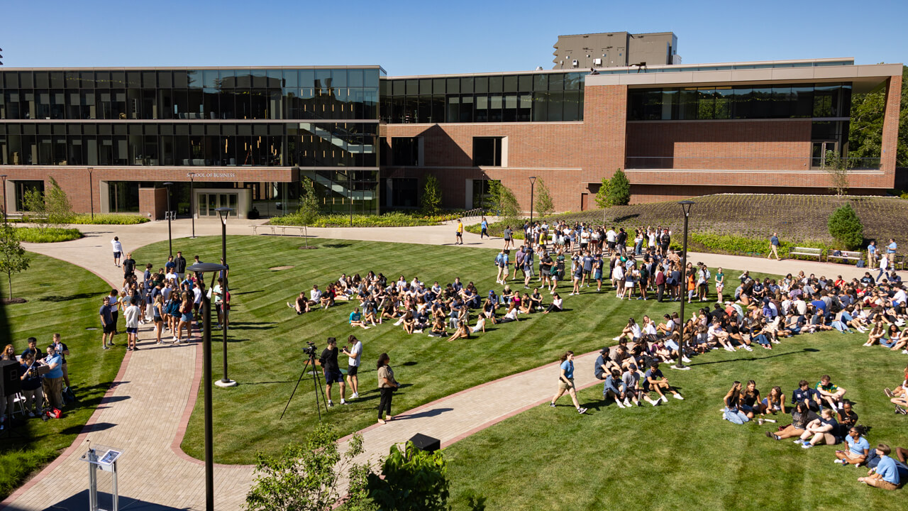 Hundreds of students sit on the South Quad on a sunny day