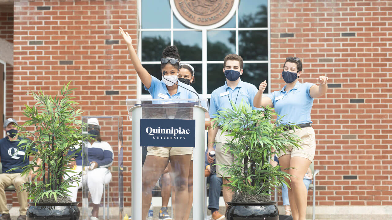 Orientation leaders cheer from the library steps