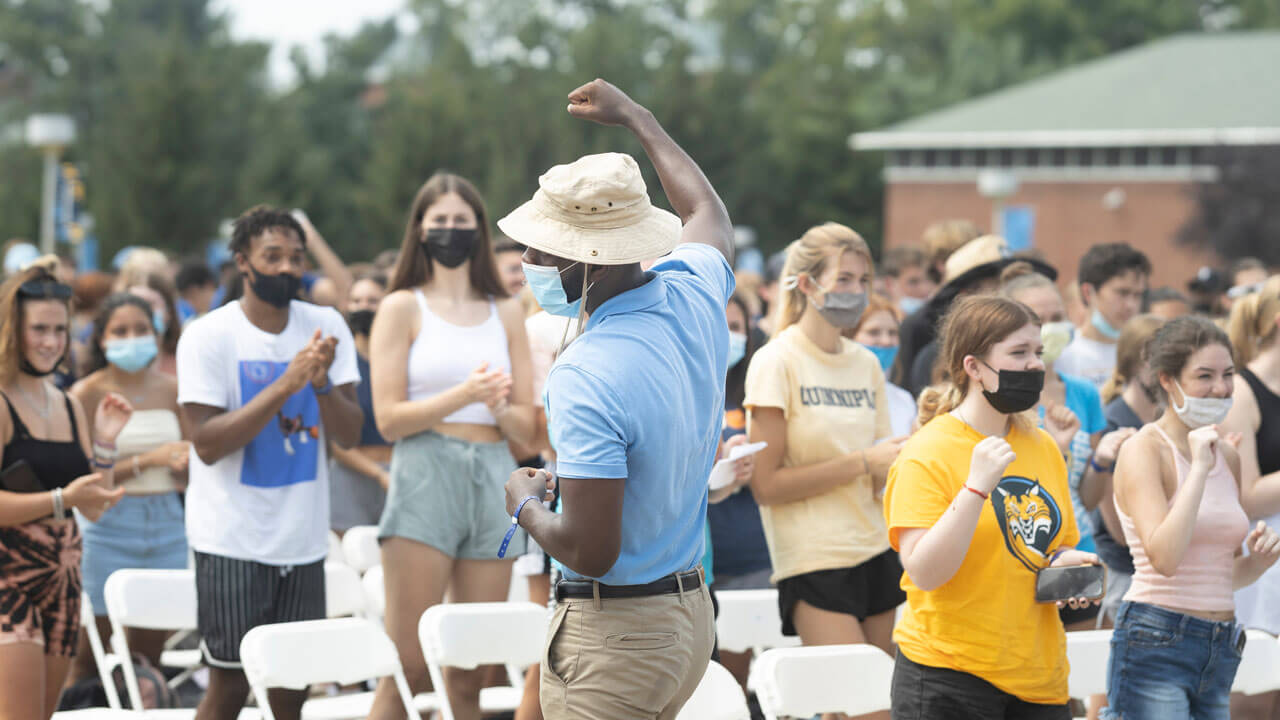 An orientation leader pumps his fist and cheers