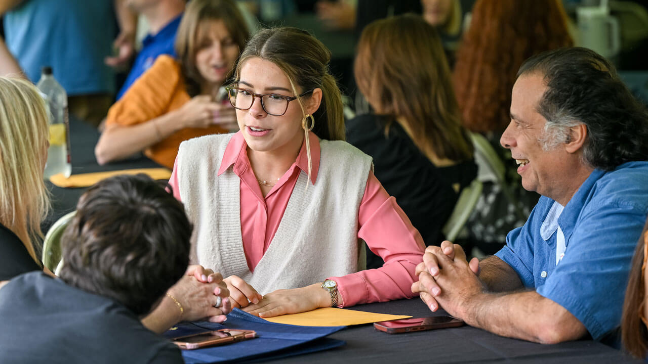 Student talking to her family at the tables