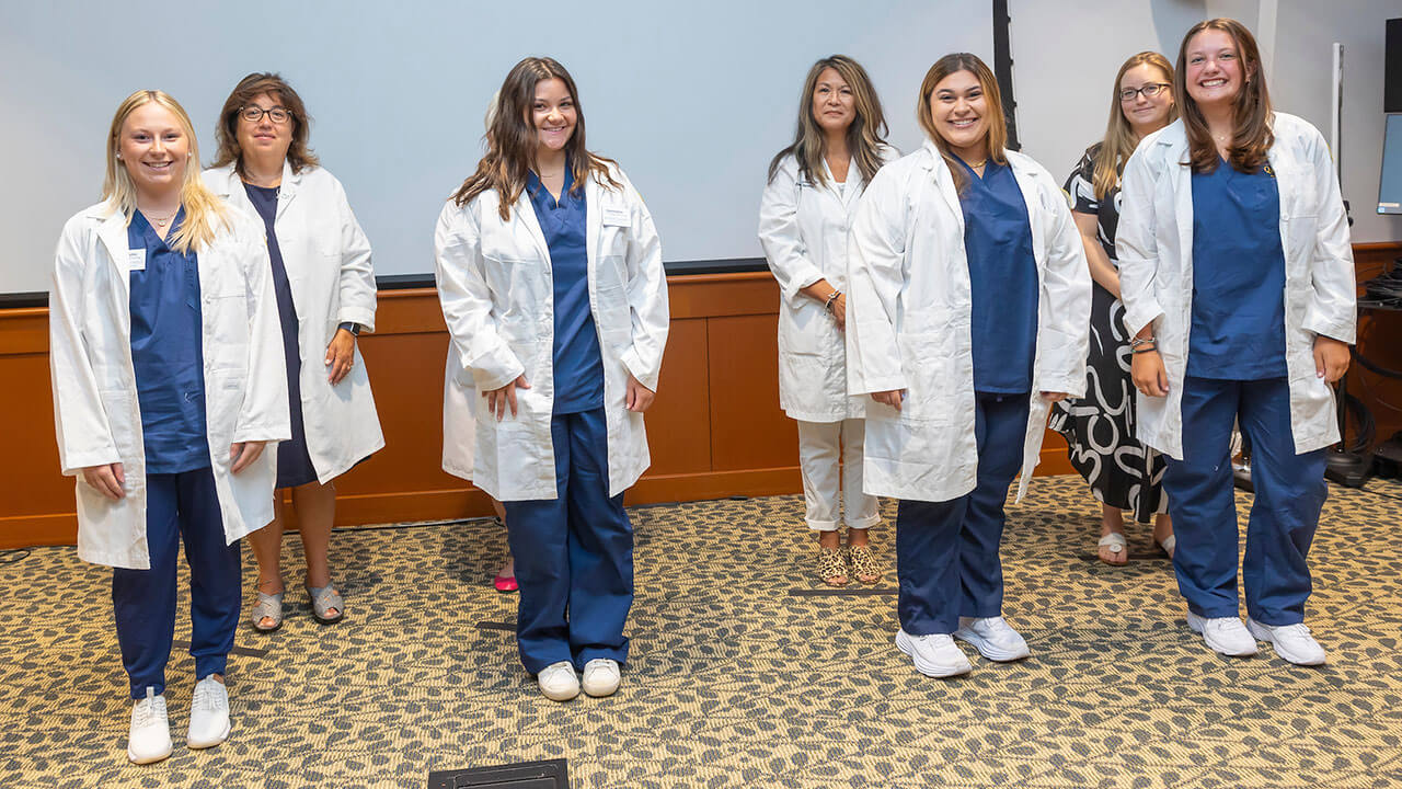 four nursing students pose with their advisors