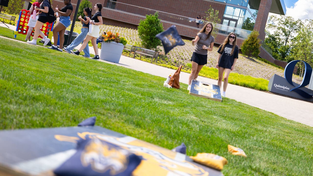 Students play corn hole on the new quad