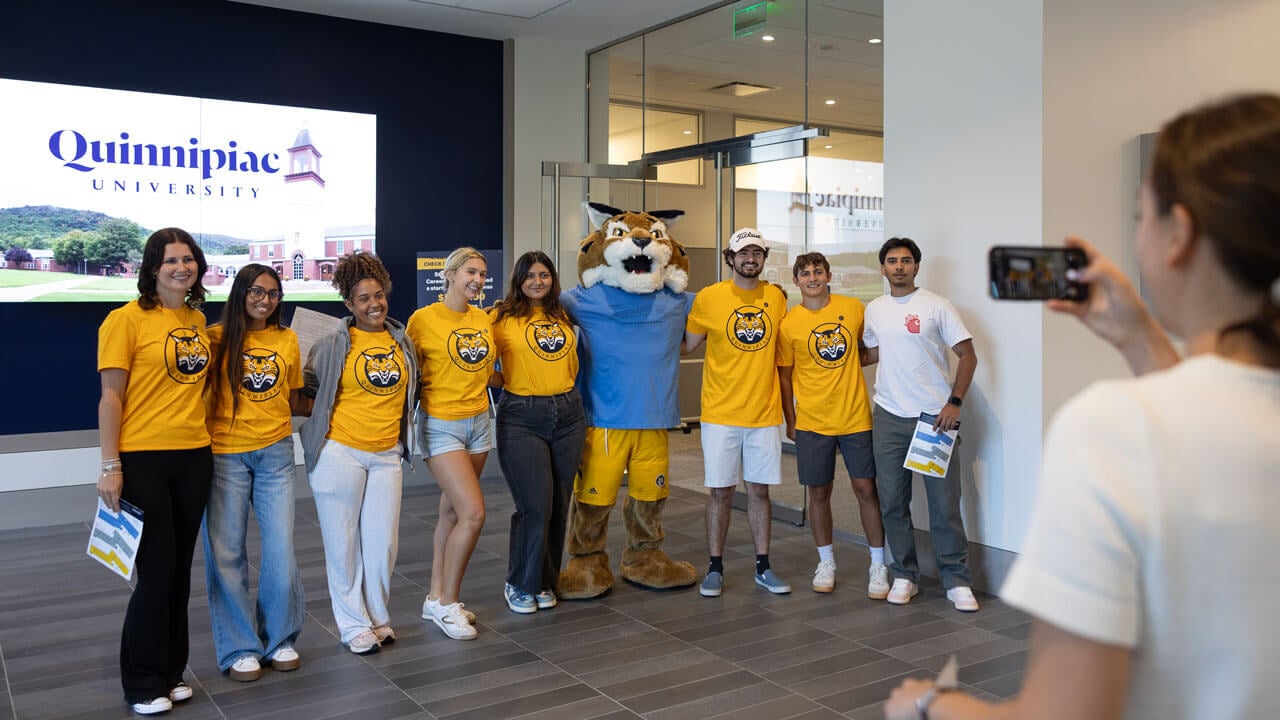 Students pose with boomer in their new Quinnipiac shirts