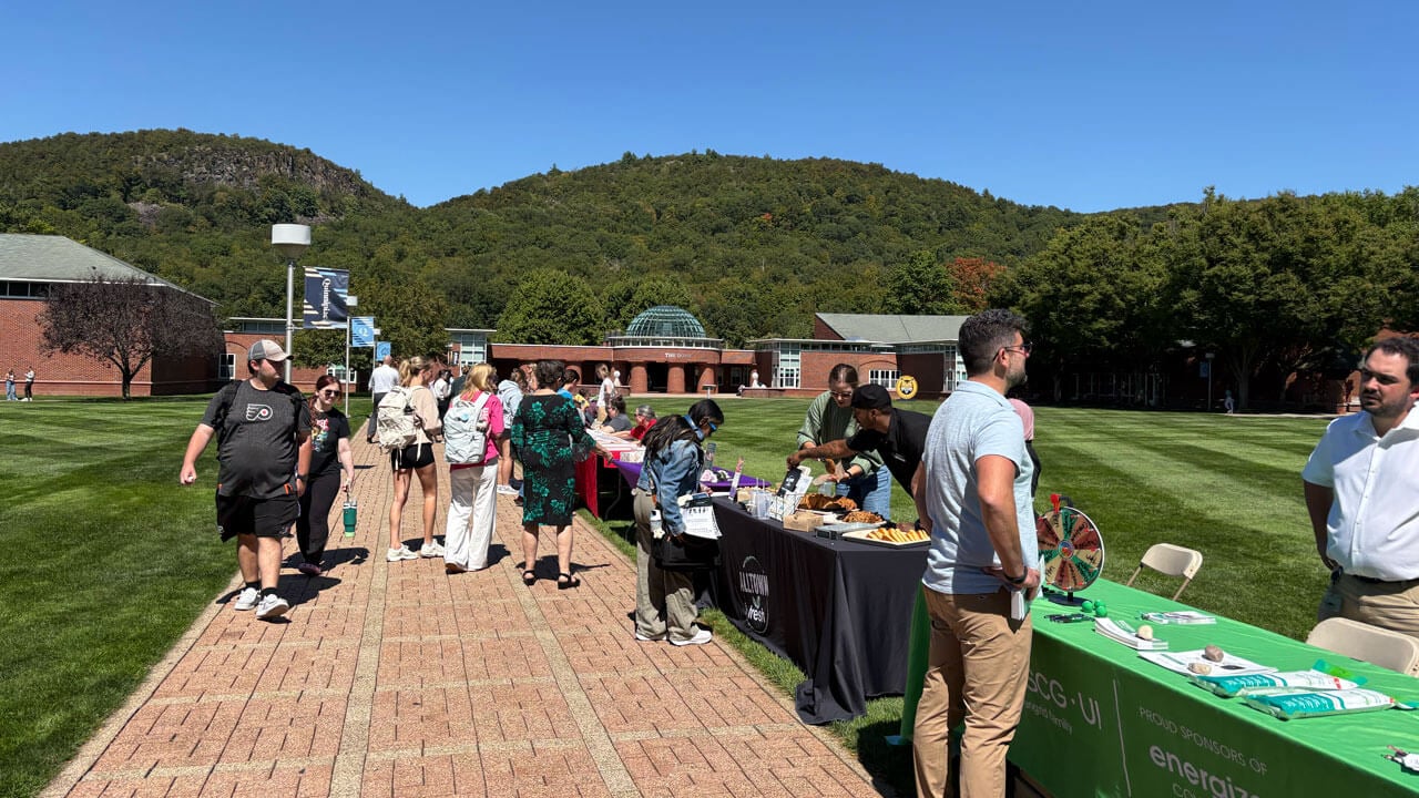 Students walk to all the entrepreneur tables on the quad