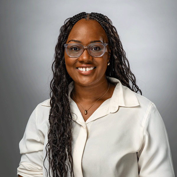 Ashley Marshall smiling against a grey background