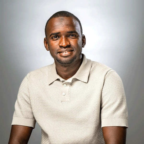 Mous Hamadou, Sr. smiling against a grey background