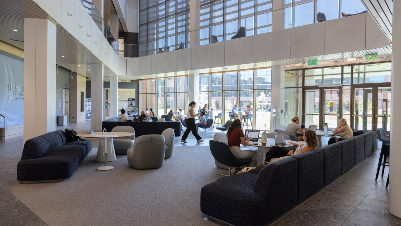 Students sit and work on two-levels while others walk through The SITE lobby