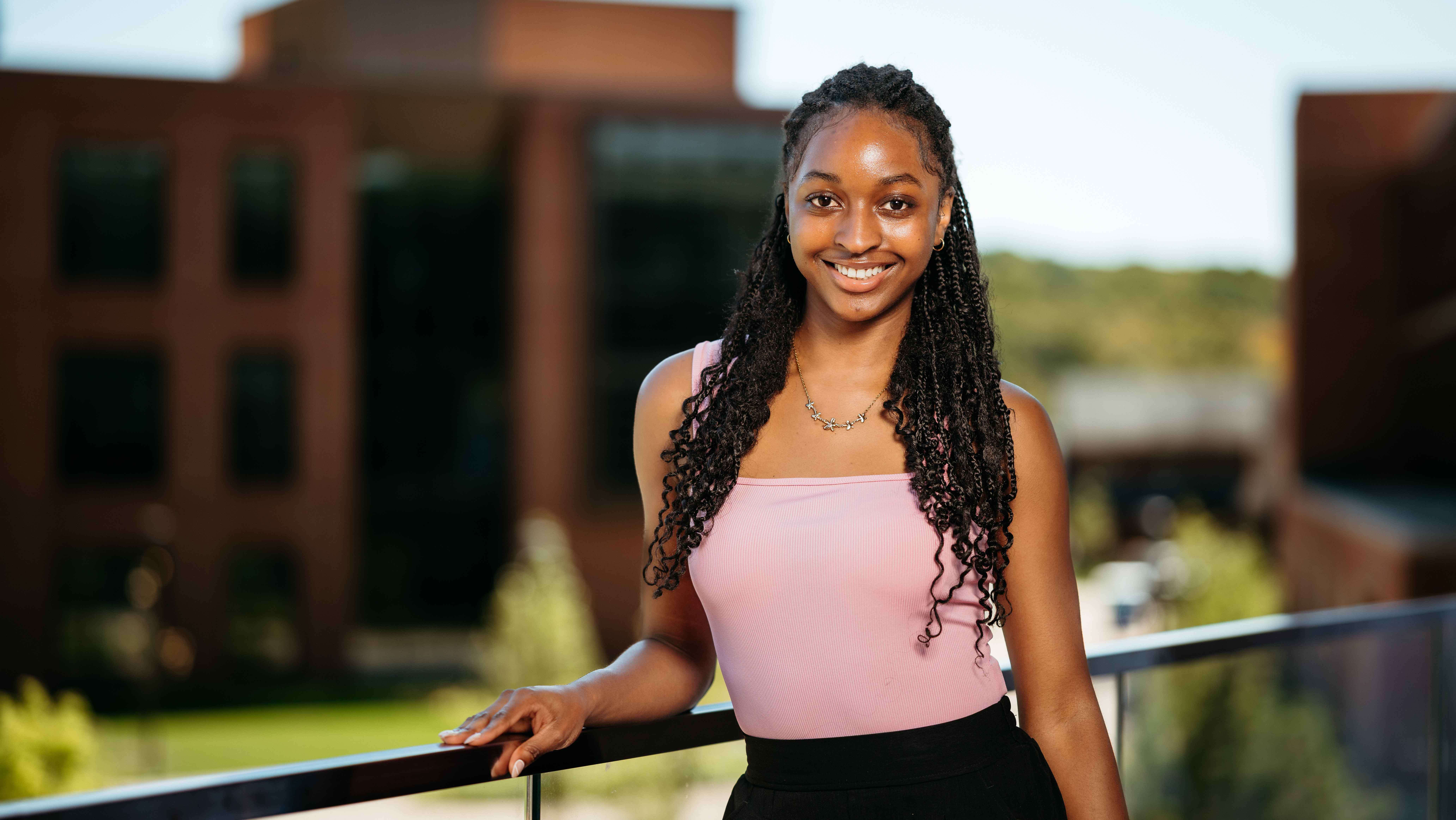 Angel Coates, a Sawhney Leadership fellow, poses for a portrait on the balcony of the School of Business on the South Quad.