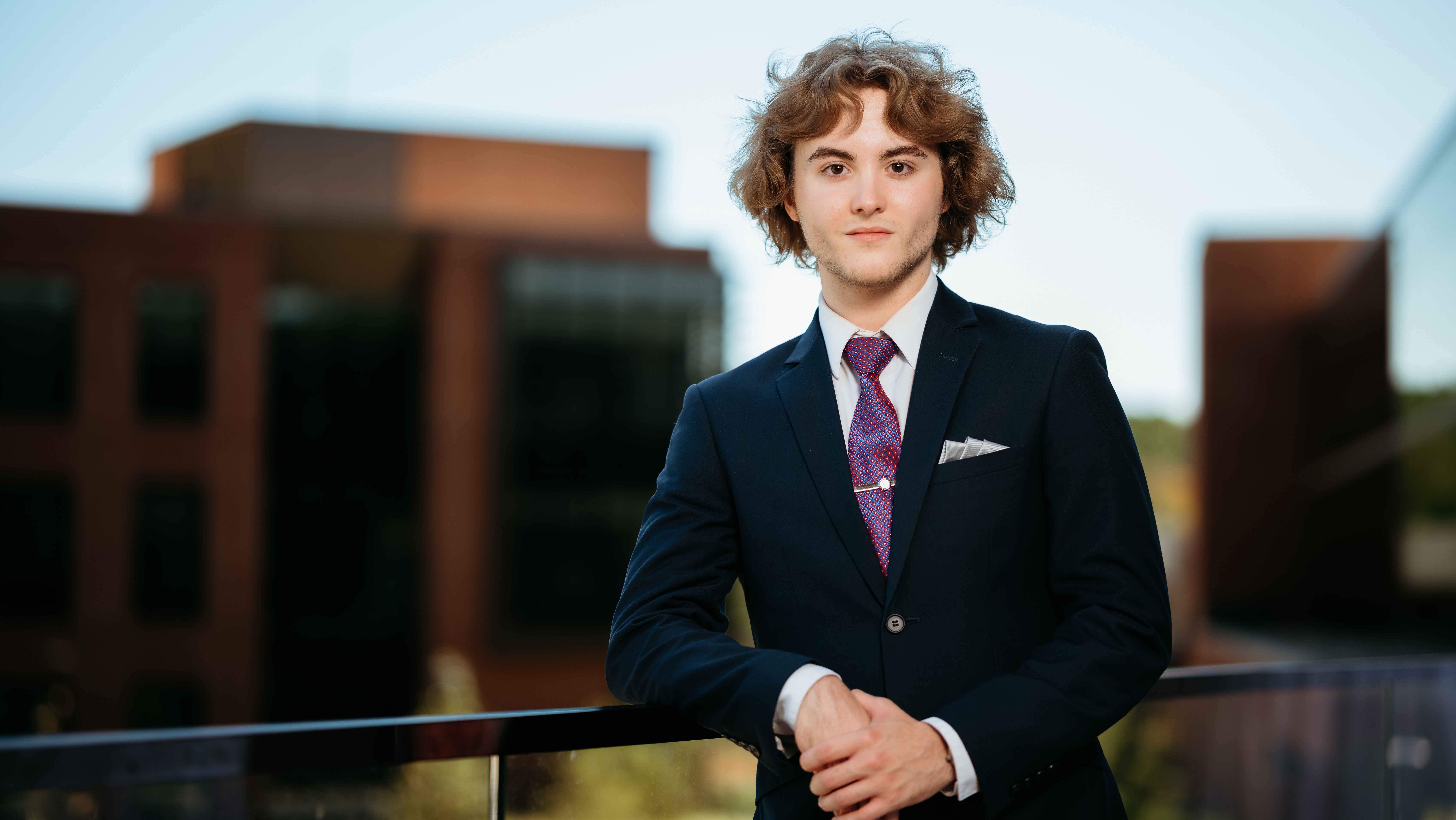 Kyle Douglas, a Sawhney Leadership fellow, poses for a portrait on the balcony of the School of Business on the South Quad.