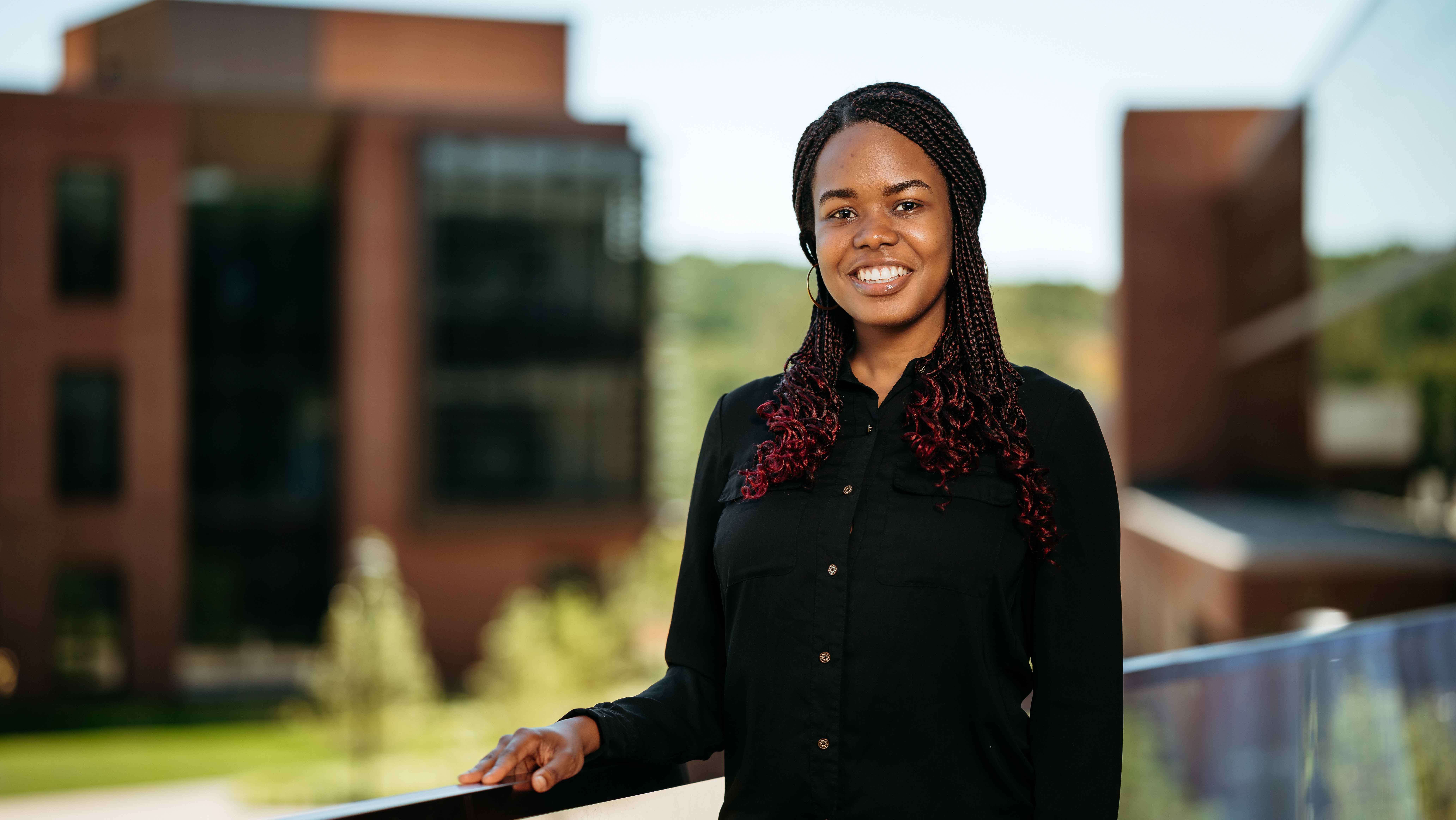 Christie Volcy, a Sawhney Leadership fellow, poses for a portrait on the balcony of the School of Business on the South Quad.