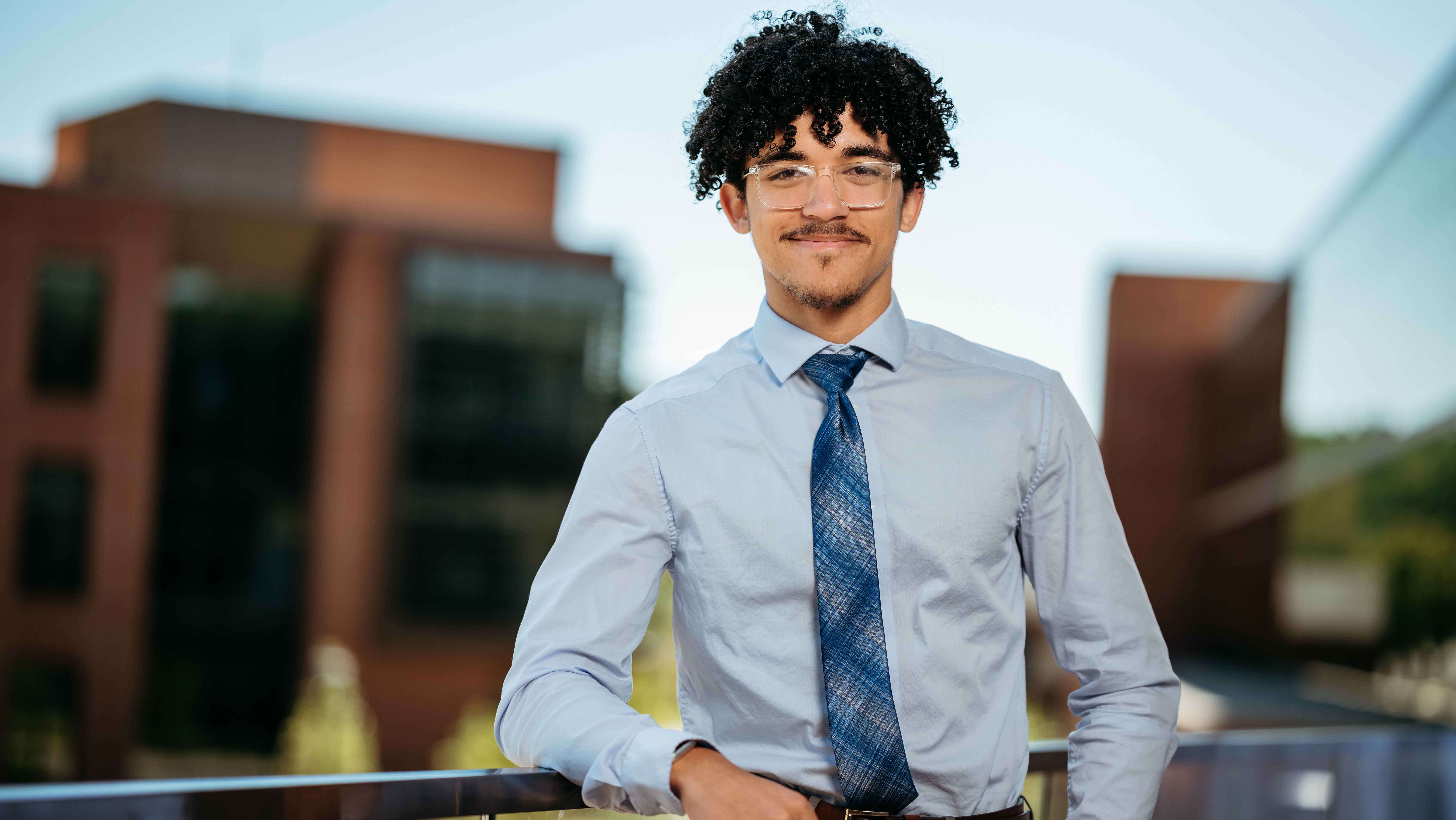 Christian Knight, a Sawhney Leadership fellow, poses for a portrait on the balcony of the School of Business on the South Quad.