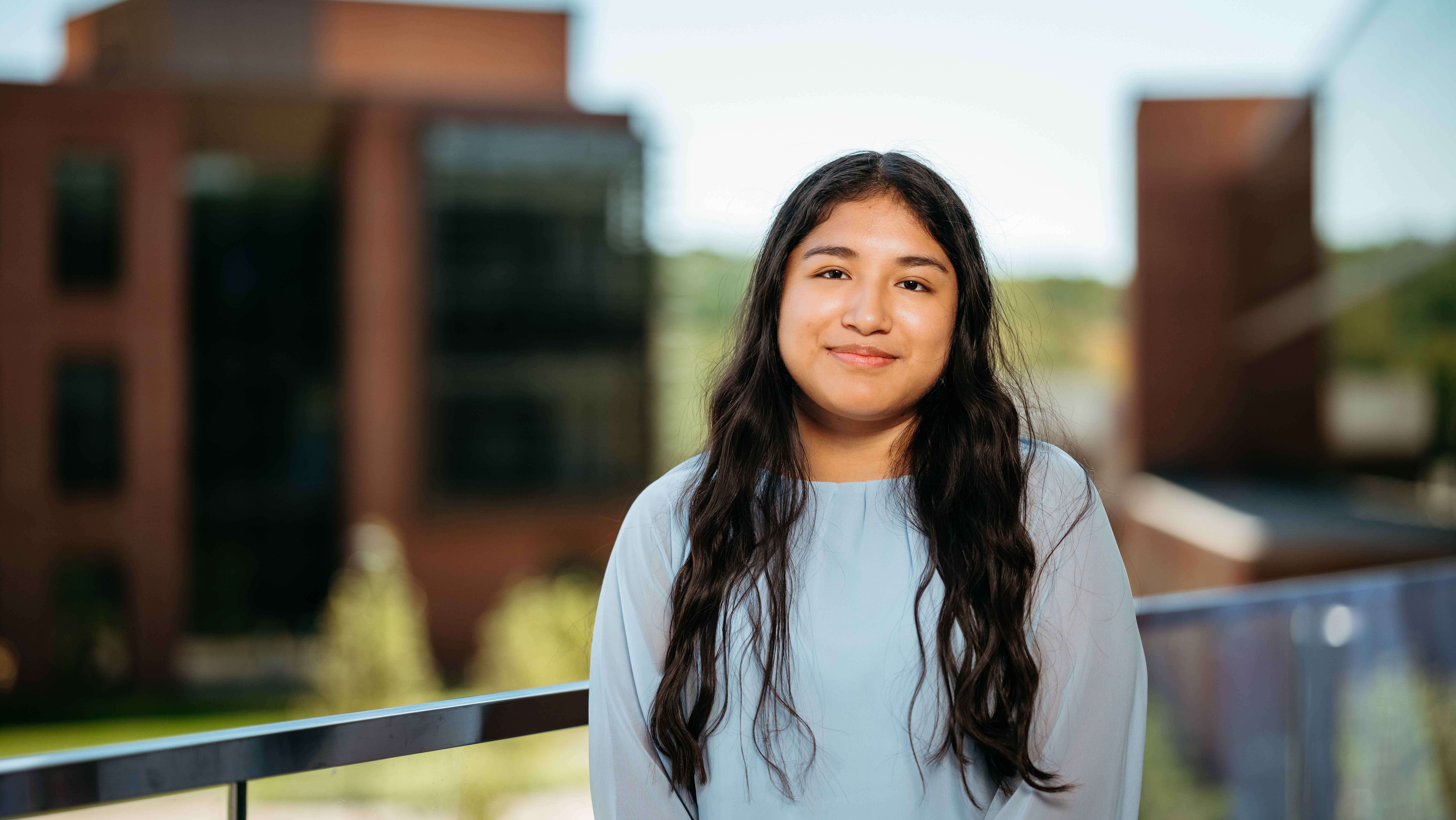 Janet Paida, a Sawhney Leadership fellow, poses for a portrait on the balcony of the School of Business on the South Quad.