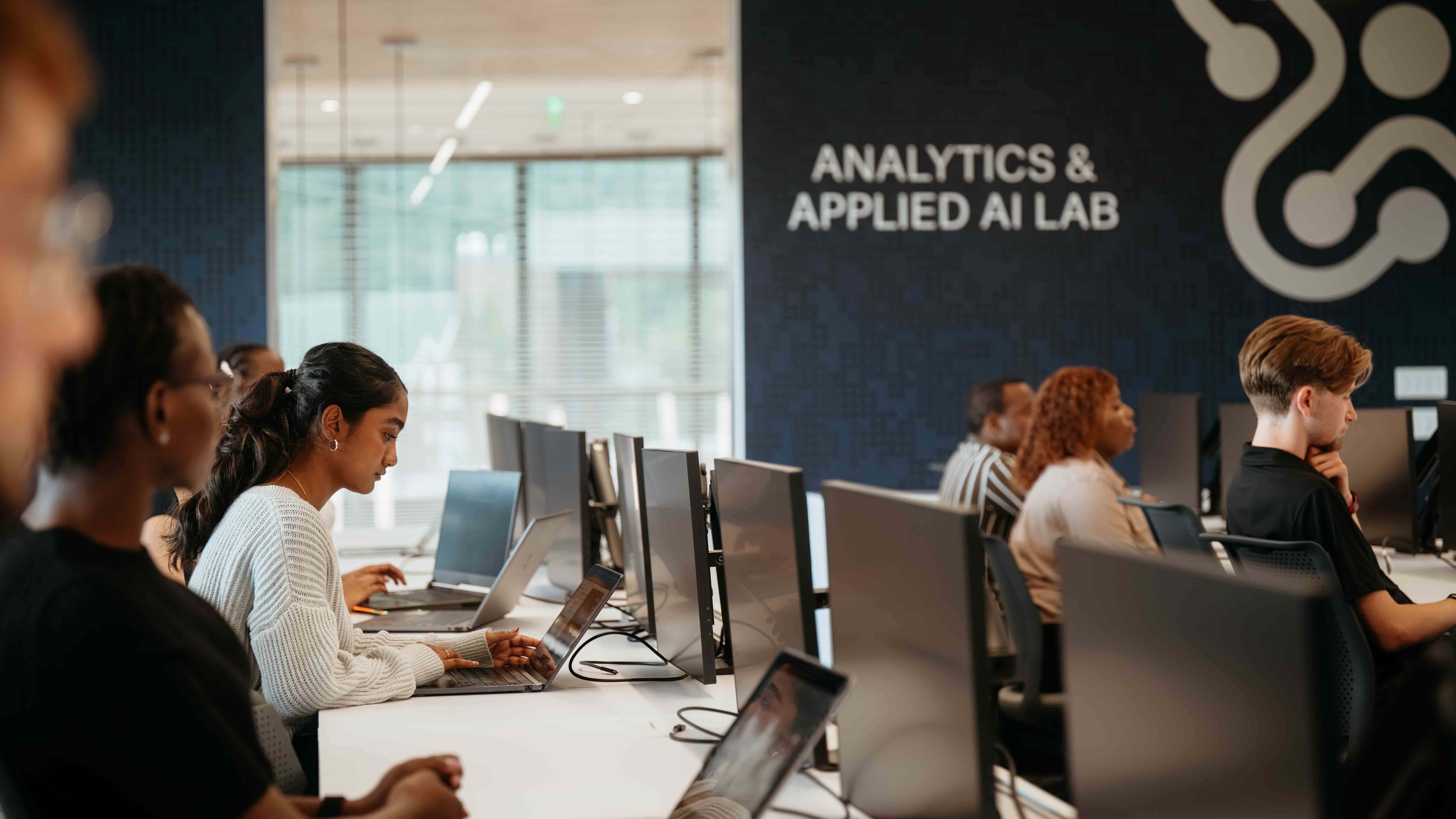 Students work on computers in the Analytics and Applied AI lab.