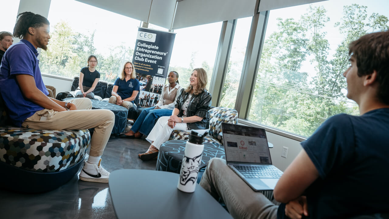 Dean of the School of Business, Holly Raider, has a conversation with students in the Innovation Hub.