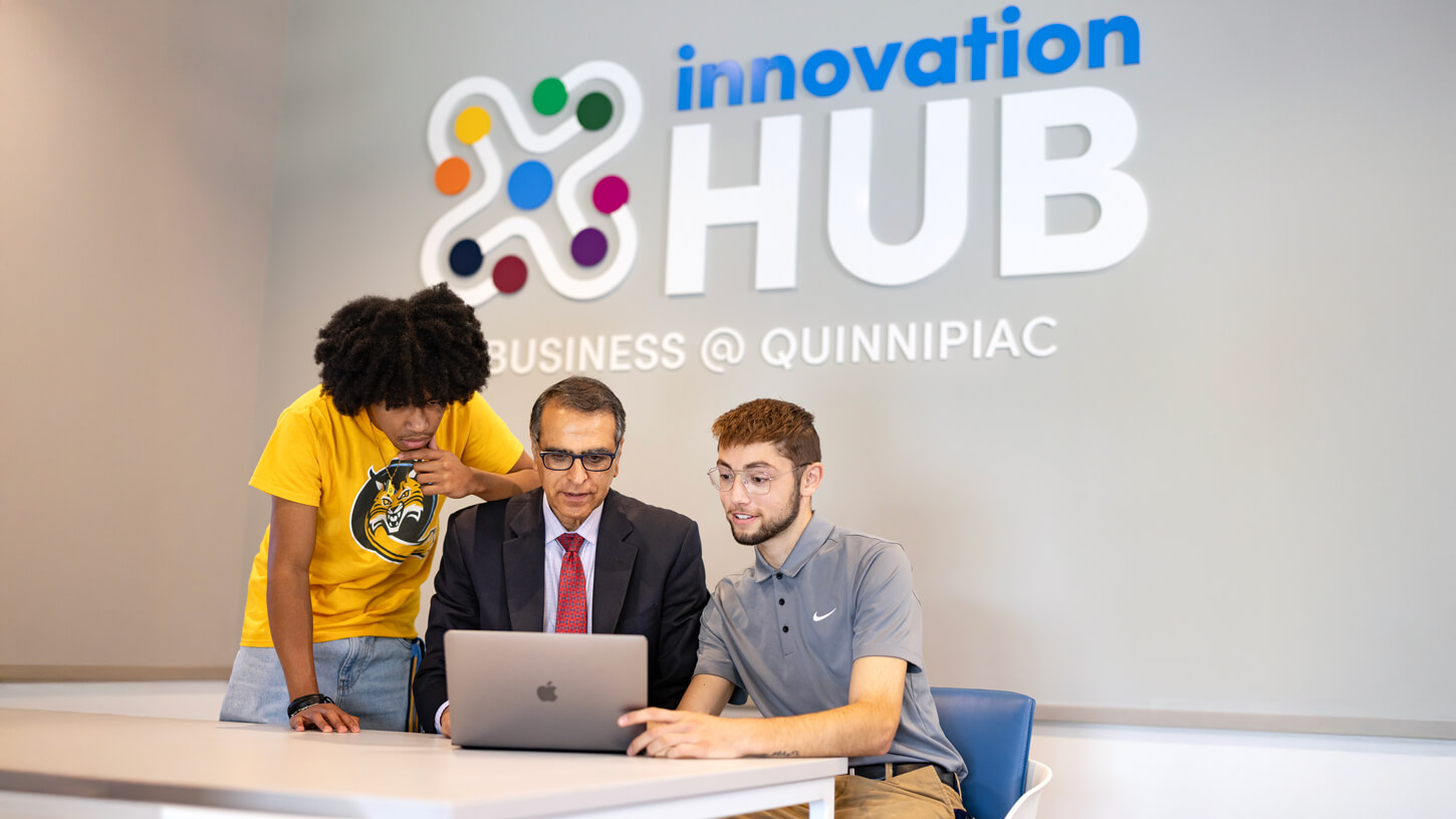 Business professor Mostafa Analoui works with two students in the Innovation Hub.