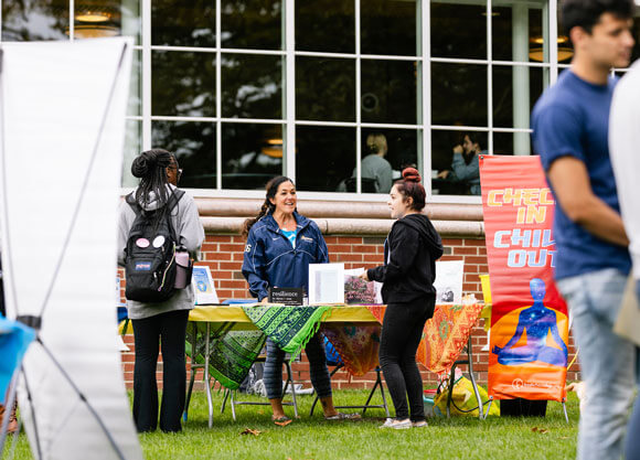 Students and faculty member are hanging out at a Fresh Check day booth.