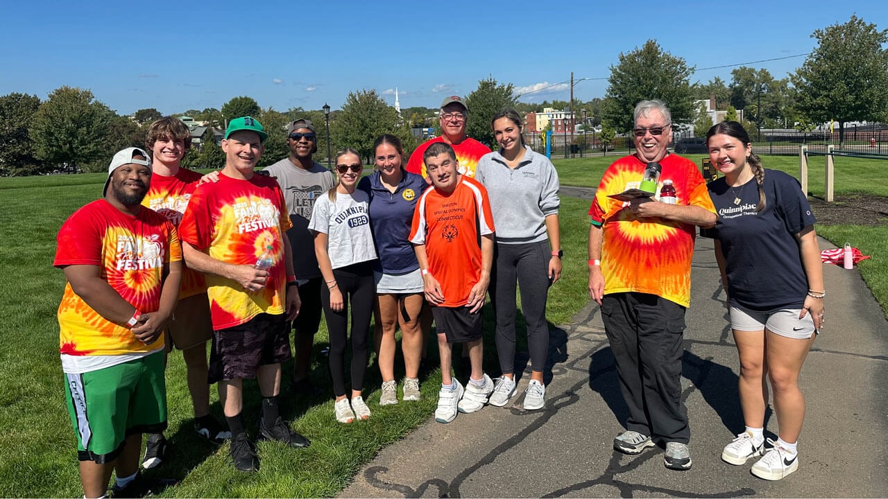 A group of athletes in matching shirts pose for a picture.