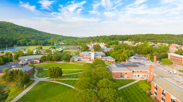 Aerial view of Mount Carmel Campus quad and several buildings and residence halls on a blue sky day