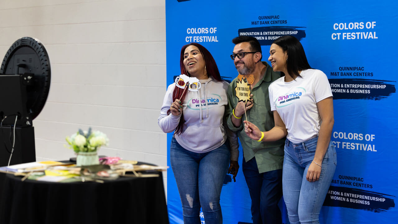 People smile at a photo booth at the Color of Connecticut festival.