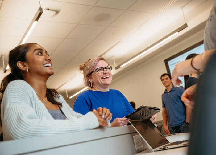 Professor Julia M. Fullick-Jagiela, conversing with students during a collaborative exercise in a classroom.