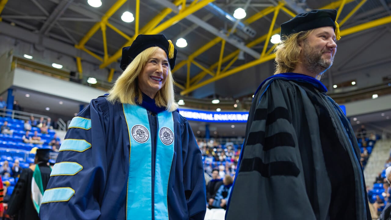 Marie Hardin and Alexander Clark walk into the ceremony in their Inauguration regalia