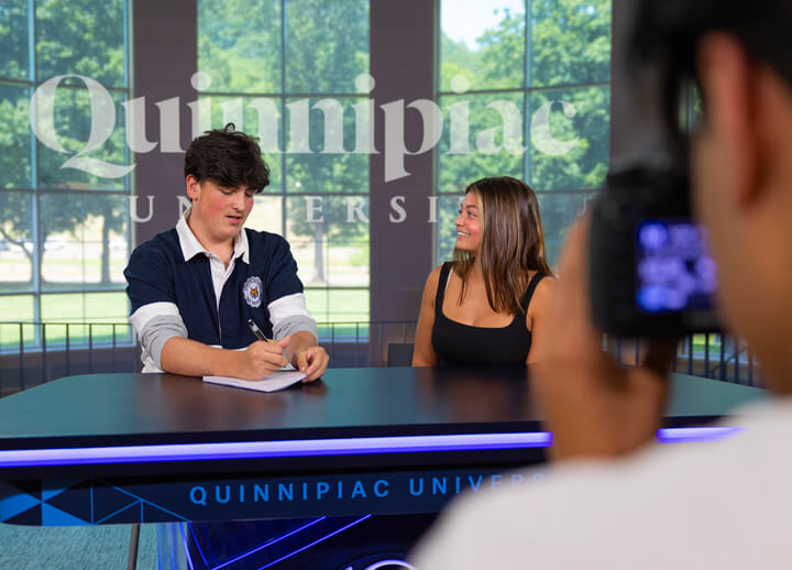 High school student Andrew Kiang photographs George Santoli (left) interviewing Madeline Crosby (right) during the Game Changers summer camp in the Open Air Studio.