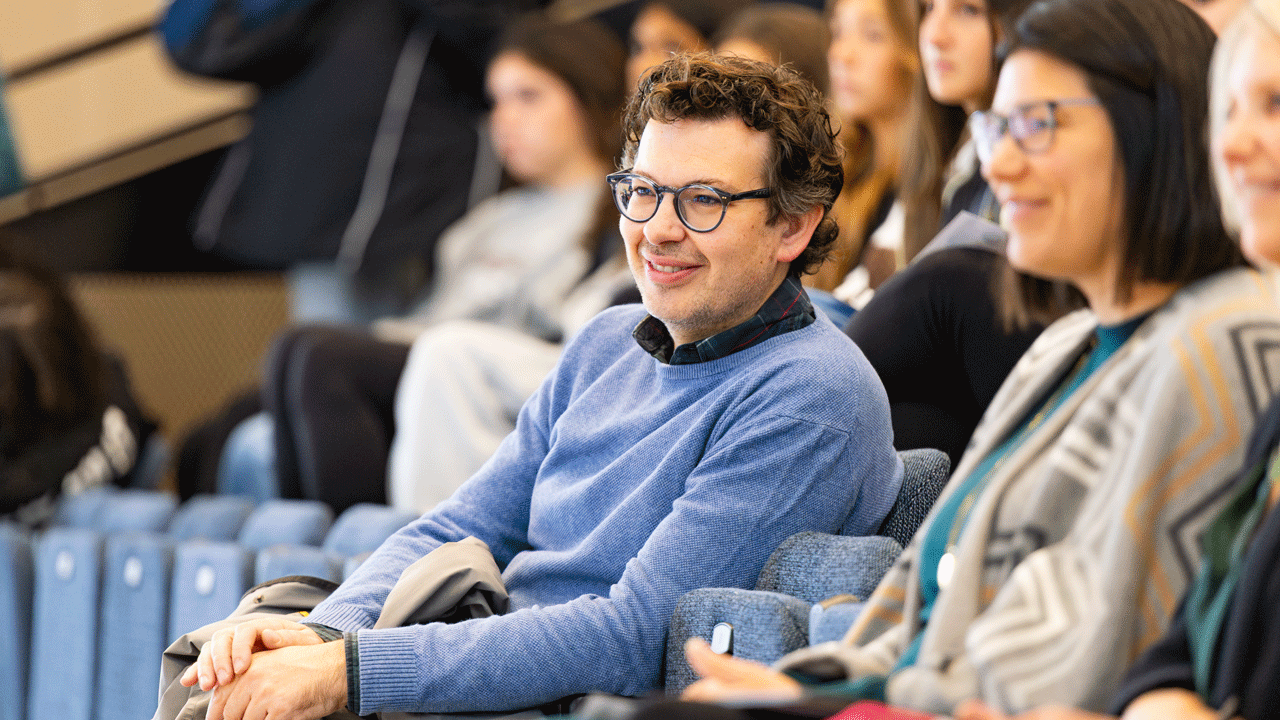 Audience member smiling while watching the panelists talk