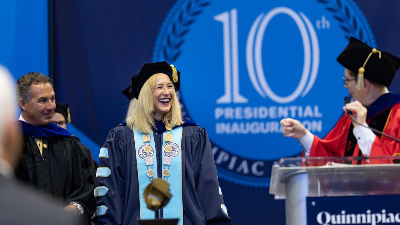 Marie Hardin and Debra Liebowitz smiling at each other behind the podium