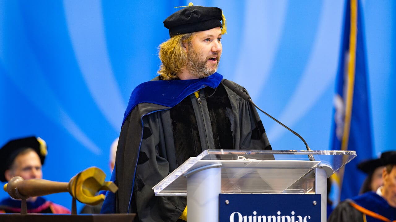 Alexander Clark speaks on stage with the ceremonial mace in the foreground