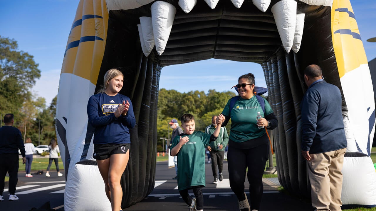 Student and adult clapping on child who finished the race