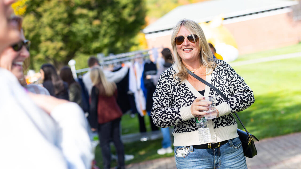 Mom smiling and talking to other parents on the quad