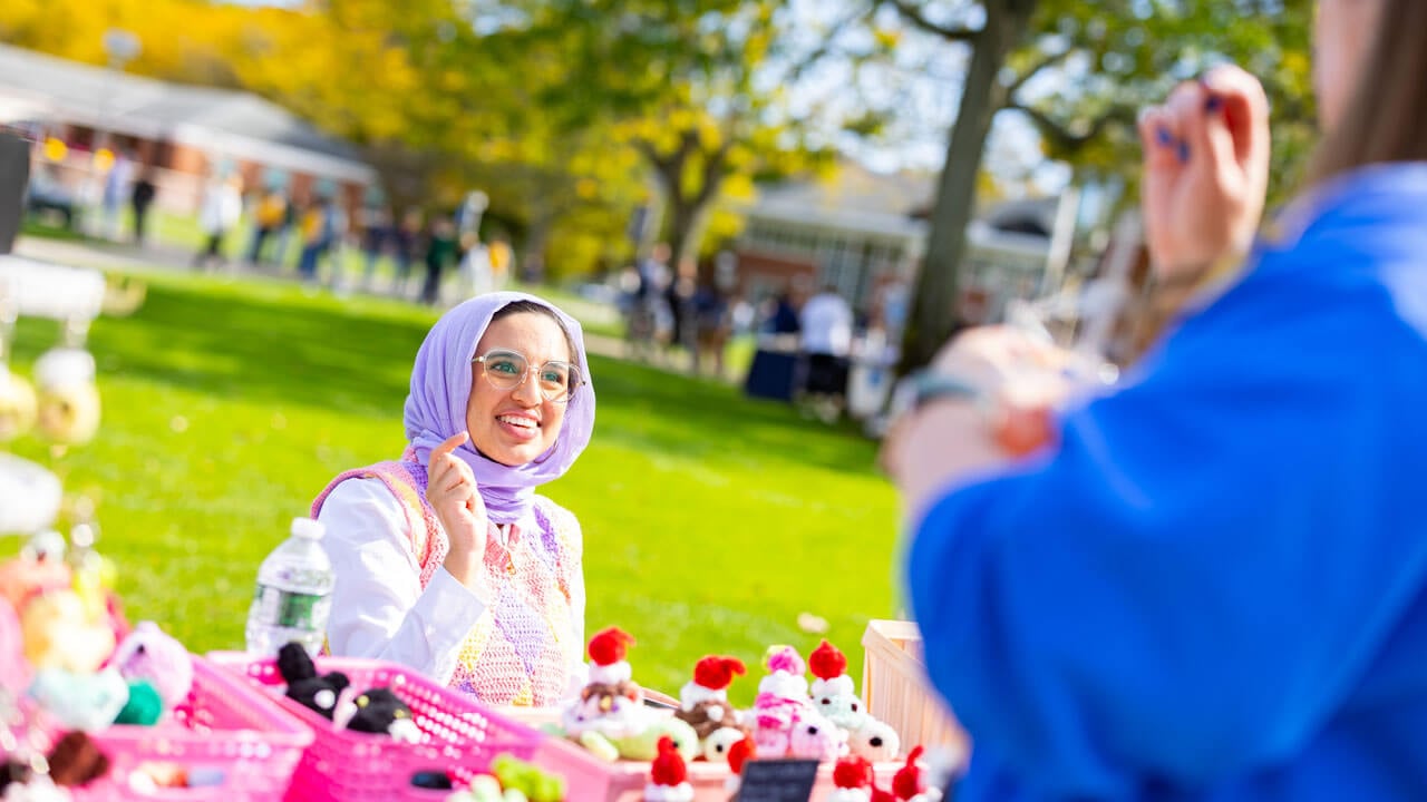 Student on the quad smiling while talking to friends
