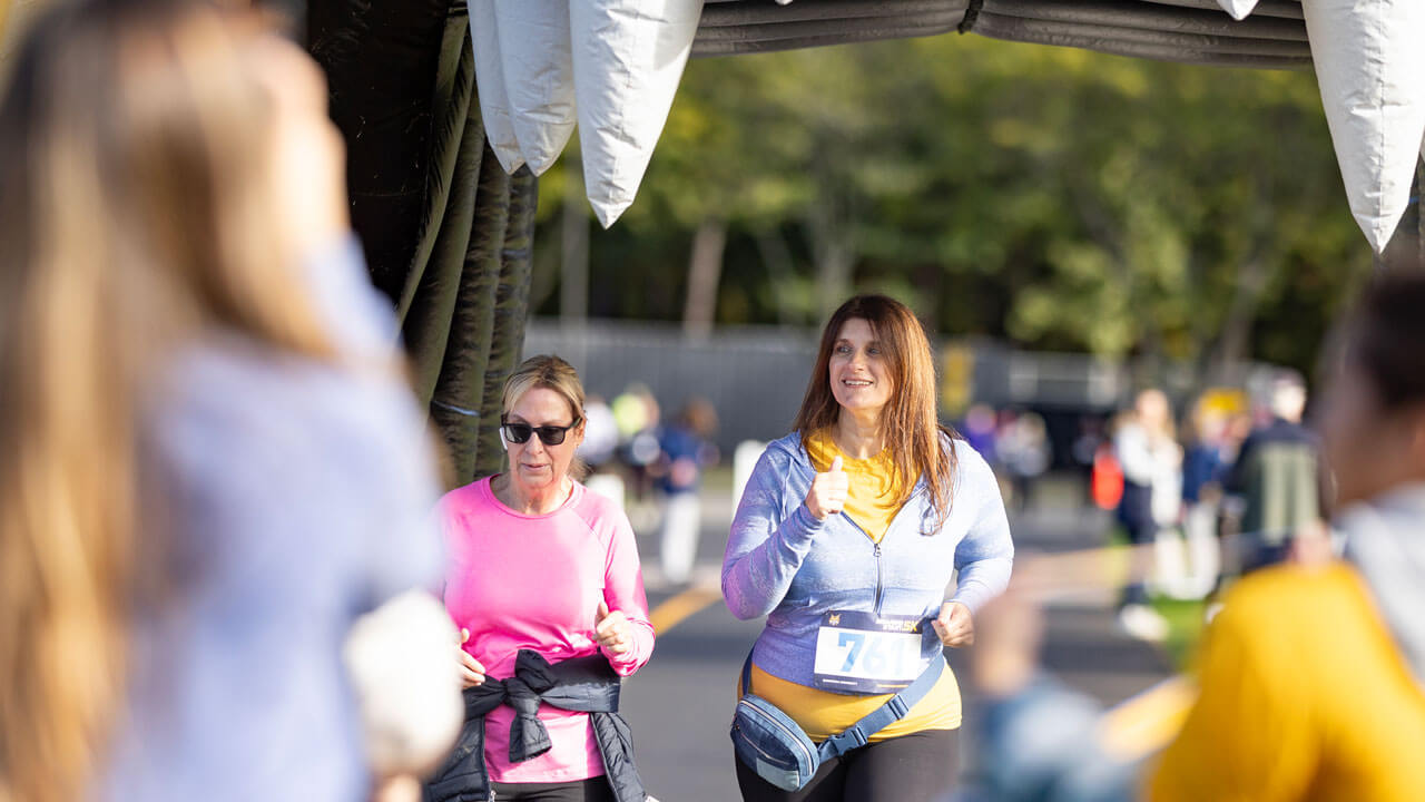 Two runners going through bobcat head to finish the race