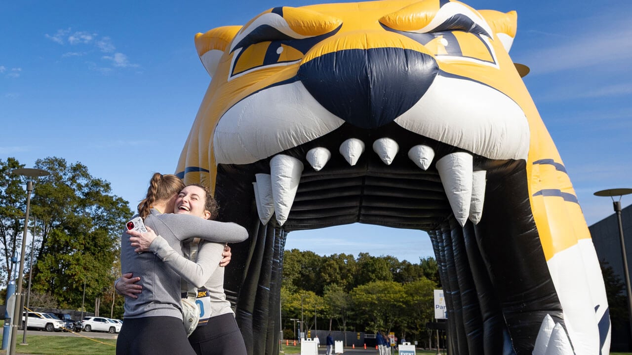 Two runners hug with smiles after finishing the 5k