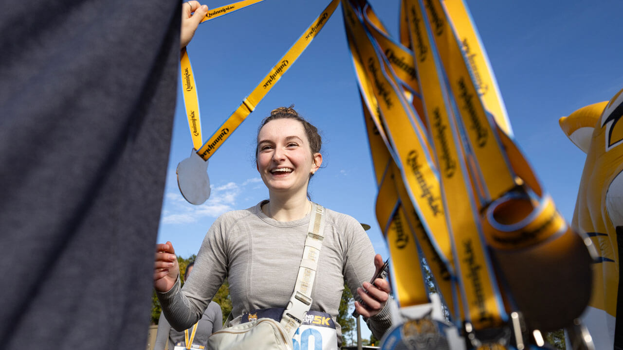 Runner with smile getting awarded a medal after finishing the race