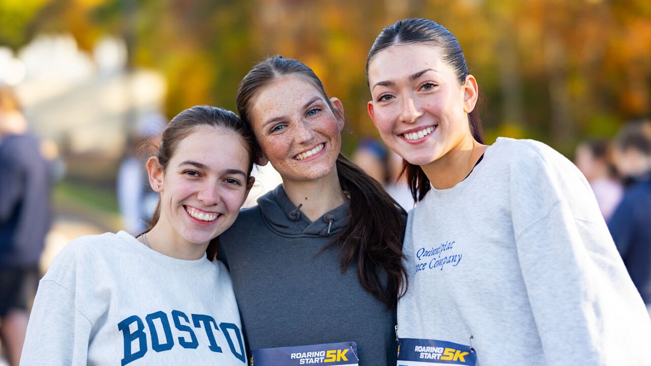 Three friends in a smiling photo before running the race