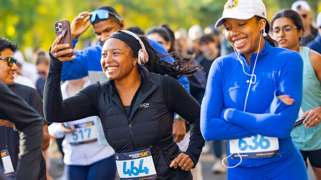 Runner smiling into phone while running the race