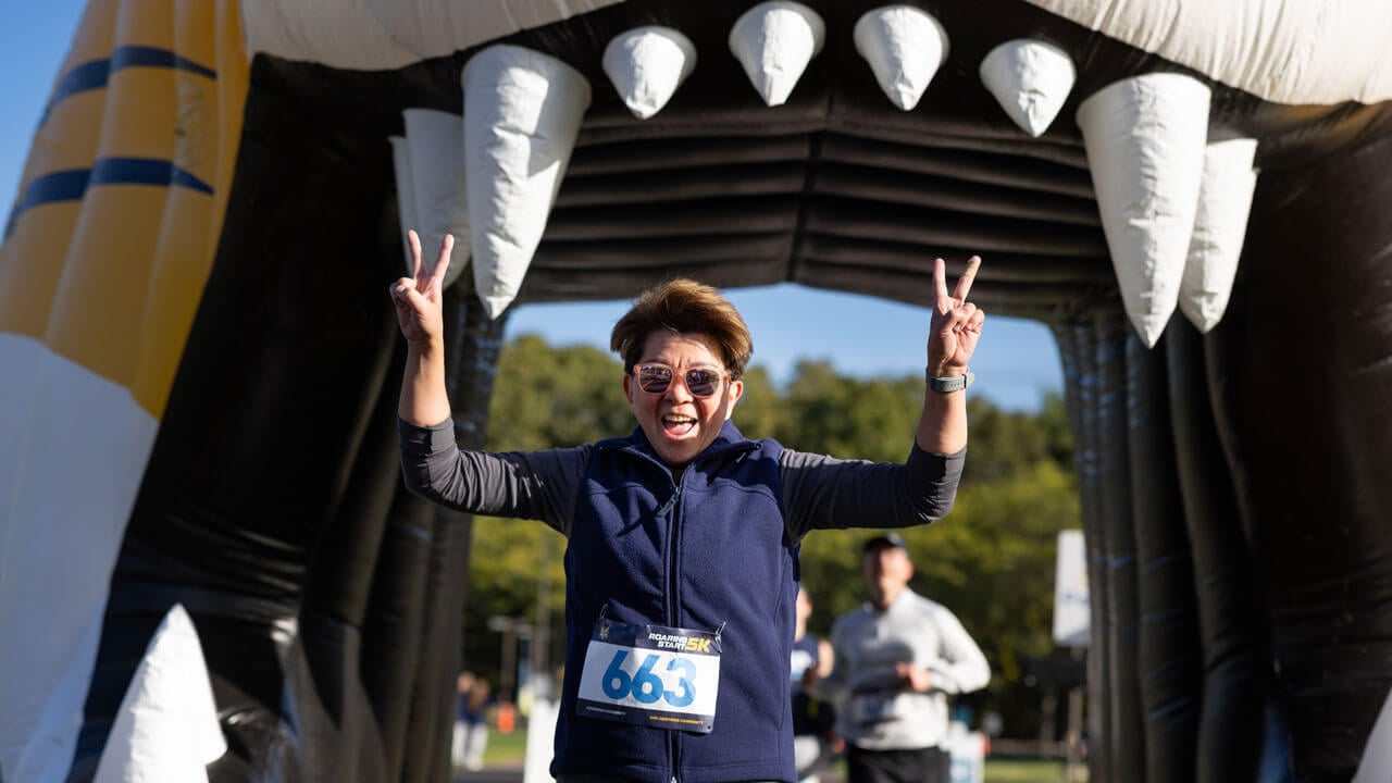 Runner finishing the race holding up two peace signs
