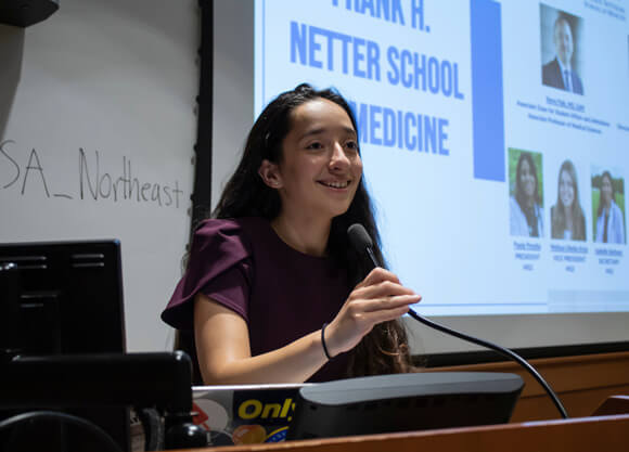 Amber Vargas speaking in front of a podium.