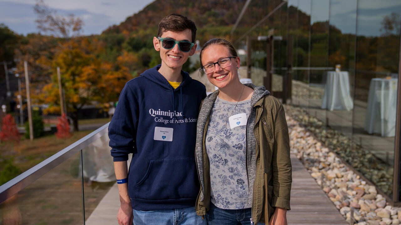A couple poses side by side together for a photo