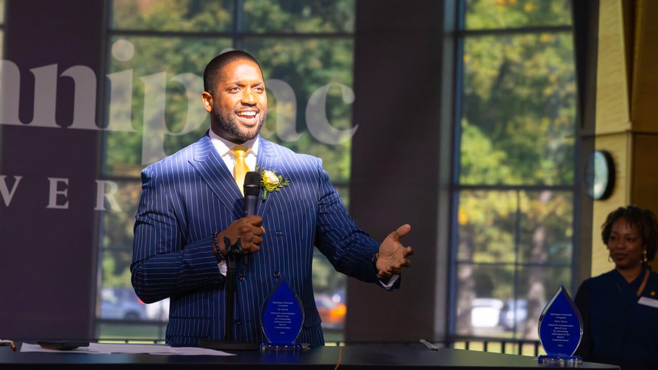 Speaker reaches his hand out towards a crowd