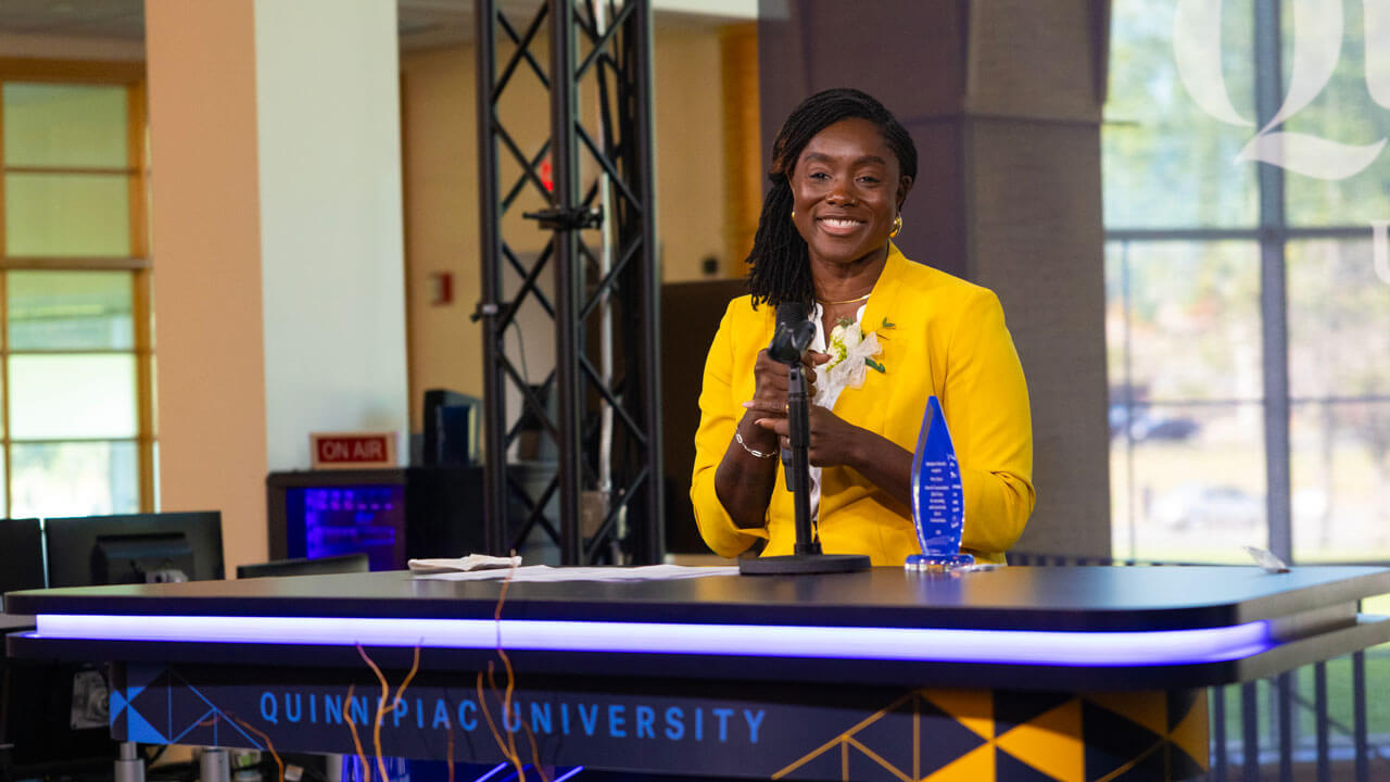 Speaker smiles at a crowd behind a podium