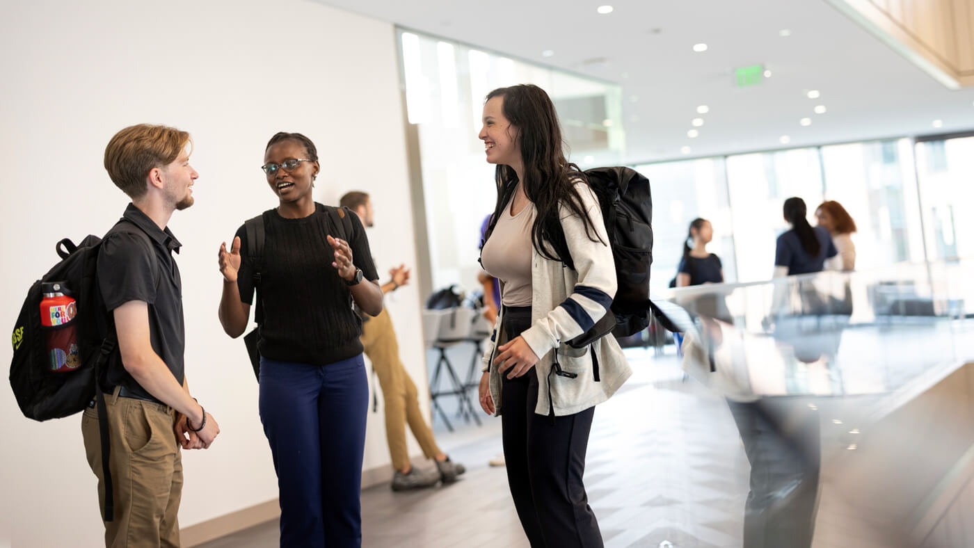 Quinnipiac University business students having a conversation in the upstairs of the new School of Business.