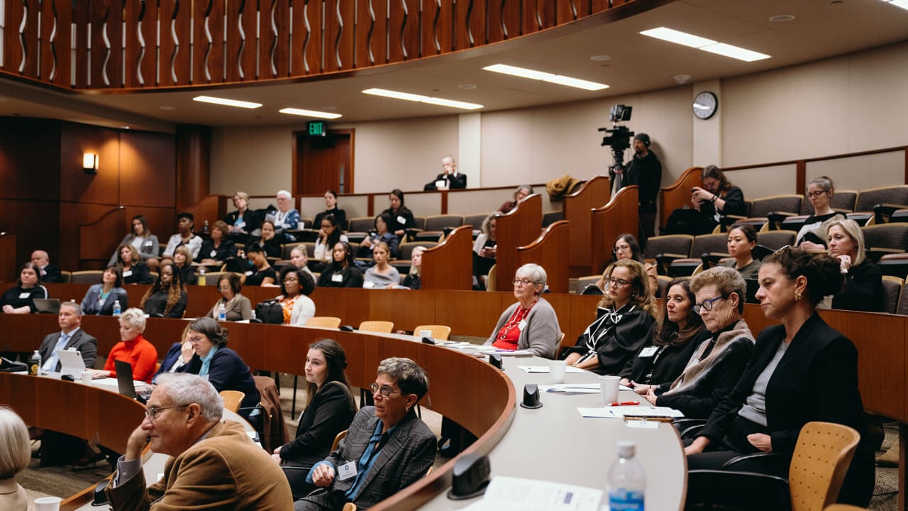 Audience members watching the panelists speak