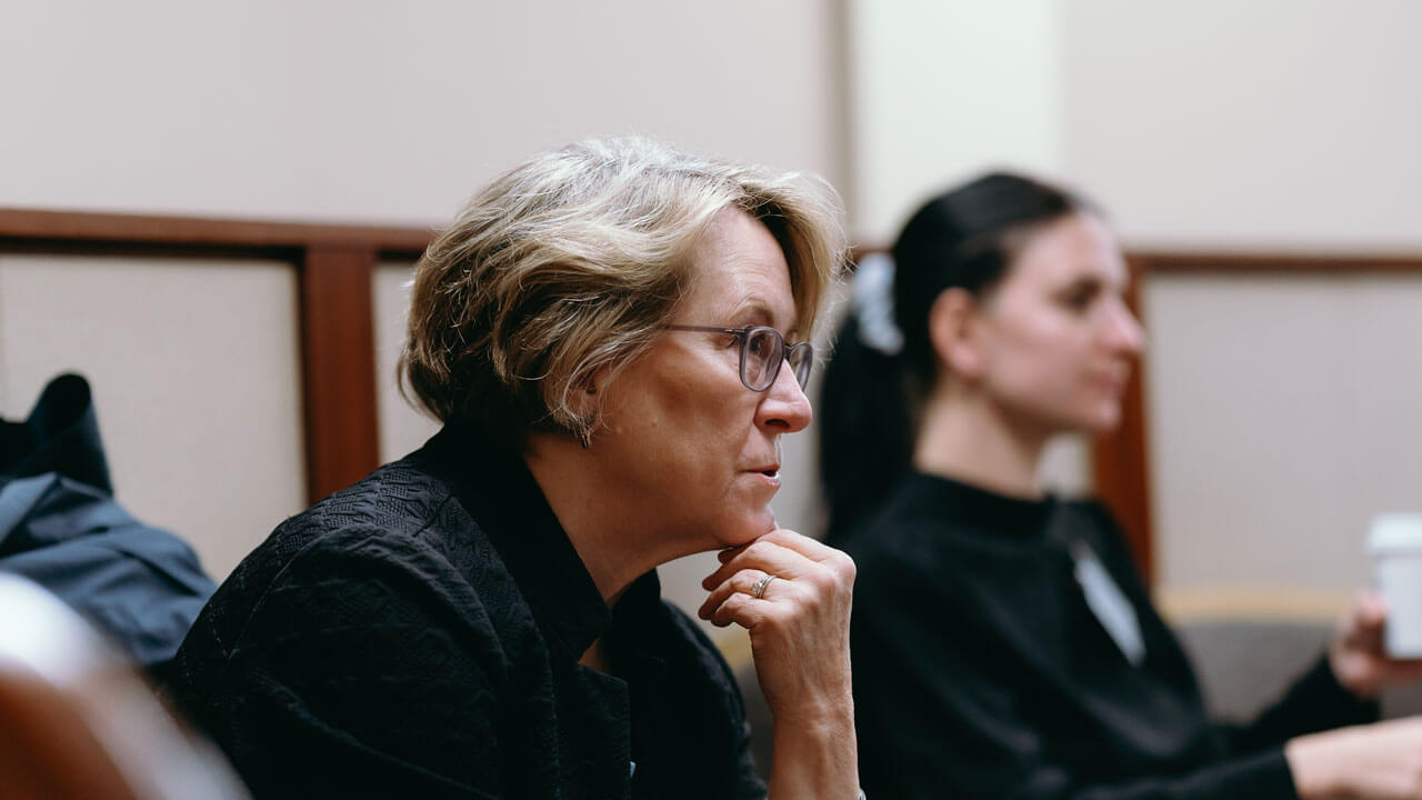 An audience member listens to the panelists with a serious face and her hand placed on her chin