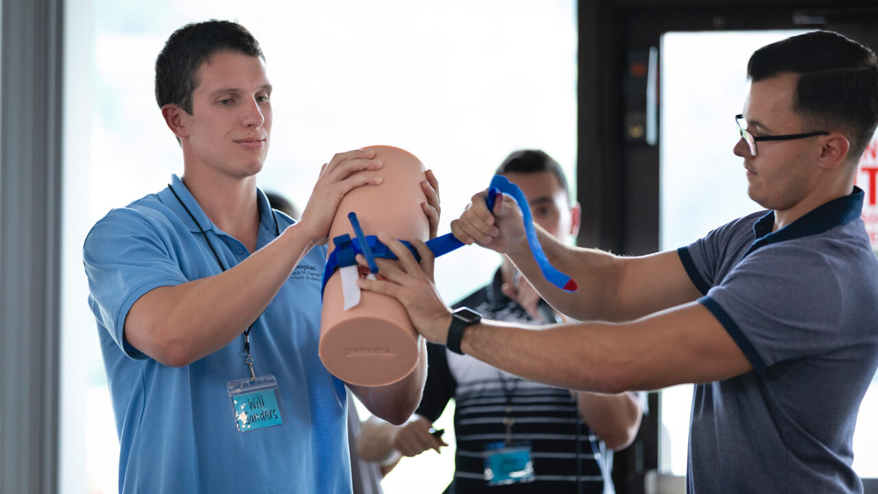 Two students demonstrating the application of a tourniquet during a lesson from “Stop the Bleed"